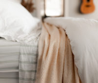 A picture containing indoor, bed, white, bedclothes Description automatically generated